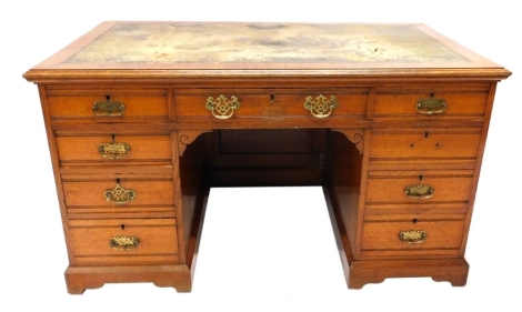 An early 20thC oak twin pedestal desk, with tooled leather top above three frieze and six pedestal drawers, on bracket feet, 78cm high, 137cm wide, 84cm deep.