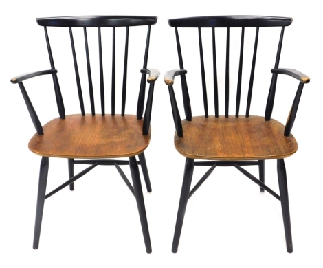 A pair of retro Melamine and ebonised stick back elbow chairs, on turned legs joined by front to back stretchers, 86cm high. (2) The upholstery in this lot does not comply with the 1988 (Fire & Fire Furnishing) Regulations, unless sold to a known exporter