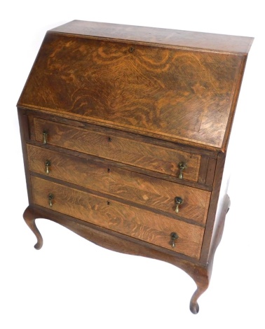 A 20thC oak bureau, the inlaid fall revealing a fitted interior with tooled leather writing section, above three long drawers, on cabriole legs terminating in pad feet, 102cm high, 77cm wide, 47cm deep.