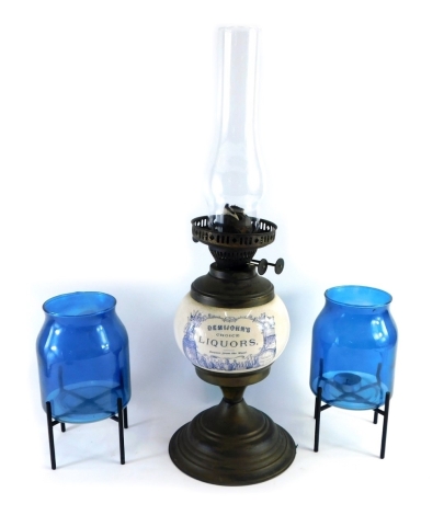 A Demijohn's Choice Liqueurs advertising oil lamp, with pottery reservoir, brass mounts and plain glass funnel, and two glass candle stands, 24cm high. (3)