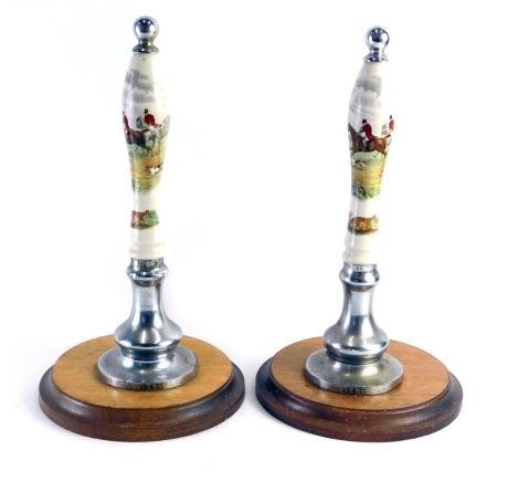 Two vintage ceramic and chrome beer pump pulls, with hunting scenes, marked 19.4.55, on inverted oak bases, 41cm high.