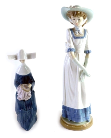 A Lladro figure of a seated nun sewing, and a Nao figure of a lady wearing bonnet, 33cm high. (2)