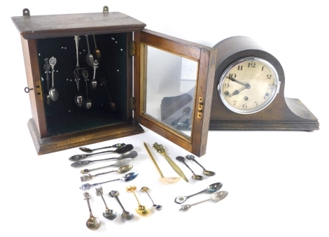 An early 20thC oak smoker's cabinet, with glazed door revealing a quantity of collectors spoons, lacking interior, and an oak cased Napoleon hat mantel clock, with chrome mounts, 15cm Arabic dial, on compressed orb feet, 43cm wide. (2)