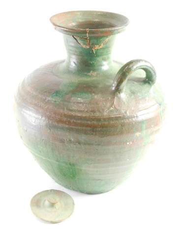 A West of England style pottery ewer with lid, with bulbous body and moulded handle, sparsely decorated with green glazes, on a ribbed ground, unmarked, 31cm high.