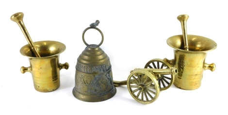 Various brassware, comprising a pestle and mortar, another smaller, a hand bell and a table cannon. (4)