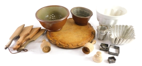 Various treen and kitchenalia, early 20thC butter pats, stoneware jelly mould, early 20thC carved wooden chopping board, 30cm diameter, various pastry cutters, etc. (a quantity)