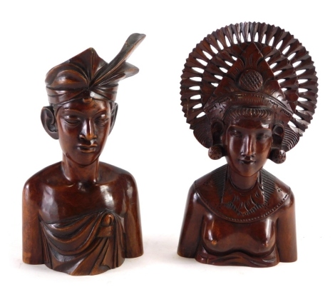 An African tribal carved figure of a lady with elaborate headdress, semi clad, 29cm high, and a further African carved tribal figure. (2)