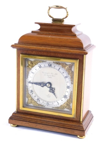 A Garrard and Co mantel clock, with Elliott movement, the 9cm diameter Roman numeric chapter ring with raised brass spandrels, in a caddy shaped case with swing handle, hand wind movement, 25cm high.