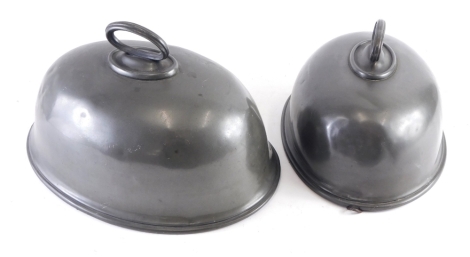 A graduated harlequin pair of pewter meat covers, 30cm wide, etc. (2)