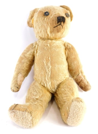 A 20thC blonde plush jointed teddy bear, with button eyes, 40cm high.