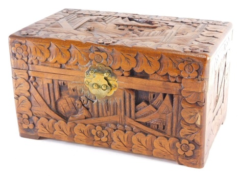 A heavily carved Chinese camphorwood box, profusely carved with figures, buildings and flowers, with plain interior, 31cm wide.