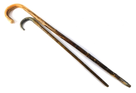 A horn handled walking stick, with gilt metal collar and bamboo style stem, 69cm long, further walking stick, and four various clock pendulums.