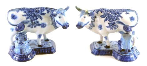 A pair of blue and white Dutch Delft milkmaid and cow figure groups, each florally decorated, marked beneath, 18cm high.