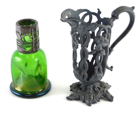 An early 20thC Art Nouveau Loetz style green glass vase, with pierced floral pewter mount, 11cm high, and a pierced ewer. (2)