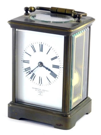 A 20thC brass Goldsmiths carriage clock, with 7cm wide Roman numeric dial, visible single train keywind movement, with swing handle, on bracket feet, 15cm high, with key.