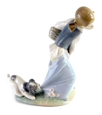 A Lladro figure of a girl, holding basket being attacked by puppy, number 66 Q-27E, printed and impressed marks beneath, 20cm high.