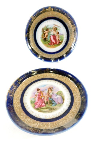 A pair of porcelain plates, in the manner of Kauffman, each decorated with classical scenes, muse, and cherubs, etc., with gilt lined blue ground borders, unmarked, 19cm diameter. (2)