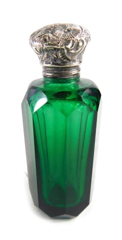 A late 19thC green glass scent bottle, with floral lid and plain T shaped stopper, 7cm high.