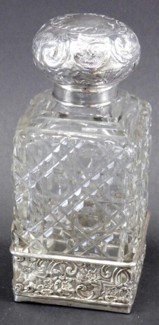 An Edward VII silver and cut glass perfume bottle, with compressed repousse decorated orb stopper, hobnail cut body, and pierced silver base, London 1903, 15cm high.