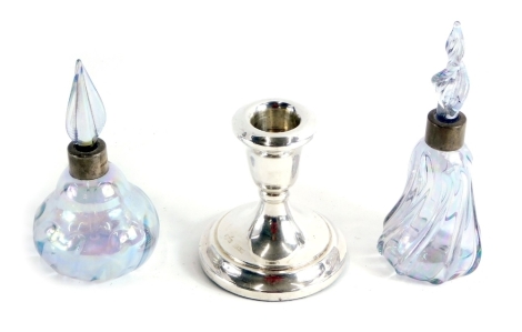 Two similar lustre glass scent bottles and stoppers, each with a silver collar Birmingham 1988 and a dwarf silver candlestick, loaded (3).