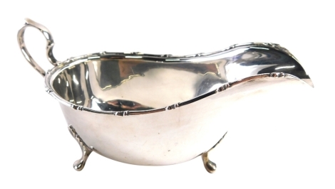 An Edward VII silver sauce boat, by the Fenton Brothers, with ear handle, acanthus capped triple paw feet and cross border, Sheffield 1904, 9cm high, 3.4oz.