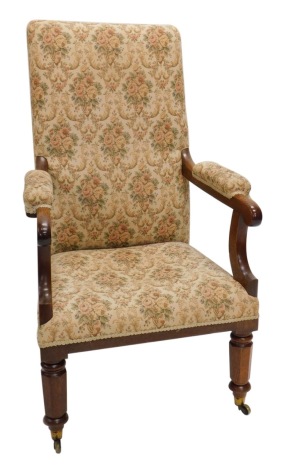 A Victorian oak open armchair, with a padded back, armrest and seat, on part turned legs with castors.