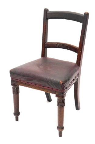 A Great Eastern Railways oak chair, with curved horizontal ladder back, overstuffed seat, in crimson leather on turned front legs, stamped G E R, 89cm high.