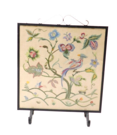 A 20thC iron fire screen, with embroidered centre, on scroll feet, 76cm high.