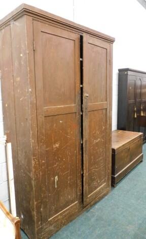 A 19thC pine kitchen cupboard, with fixed moulded cornice, above panelled doors, revealing shelves, 210cm high, 132cm wide, 59cm deep.