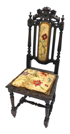 A 19thC Carolean style oak dining chair, with embroidered back and seat in floral material, surmounted by heavily carved lions, and centred by a shield, on turned front legs, joined by a H stretcher, 113cm high.