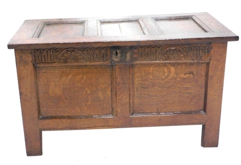 An 18thC oak coffer, the three panelled top hinging to reveal a plain interior, with carved frieze and two further plain panels to the front, on block stiles, 60cm high, 99cm wide, 53cm deep.