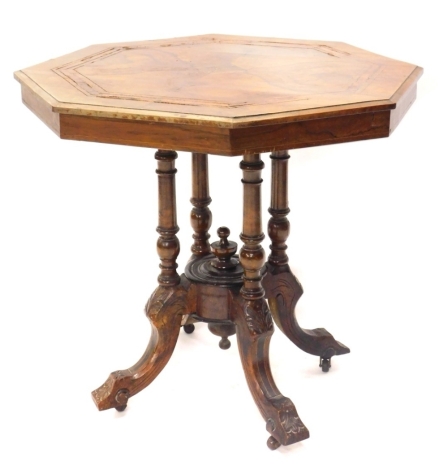 A late Victorian walnut and inlaid octagonal occasional table, on turned supports with inverted scroll floral carved legs terminating in castors, 70cm high, 77cm wide, 75cm deep.