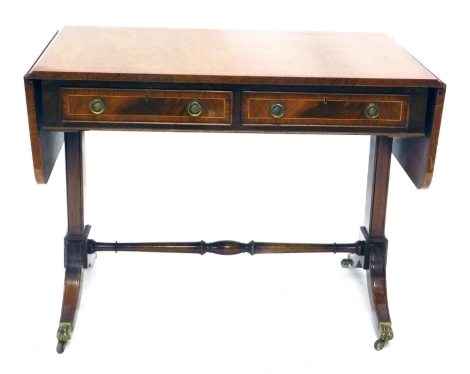 A 19thC mahogany sofa table, with two frieze and two dummy drawers with ring handles, on sabre legs terminating in hairy paw feet with brass castors, joined by a horizontal stretcher, 75cm high, 100cm wide, 66cm deep.