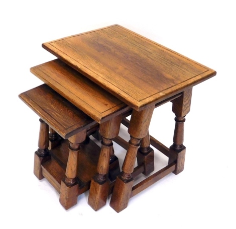 A nest of three Titchmarsh & Goodwin style oak tables, on block feet, the largest 52cm high, 54cm wide, 42cm deep.