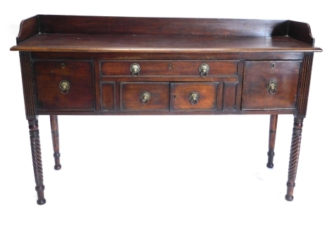 A Regency mahogany sideboard, the top with a raised back and a moulded edge above an arrangement of one narrow drawer and four panelled doors, each with brass lion mask handles on spirally turned legs, 152cm wide.