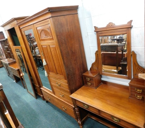 An early 20thC walnut aesthetic style bedroom pair, comprising a compactum wardrobe with dentil cornice, raised above a panelled cupboard, single glazed door and three further drawers, on block stiles, and a similar mirror back dressing table. (2)