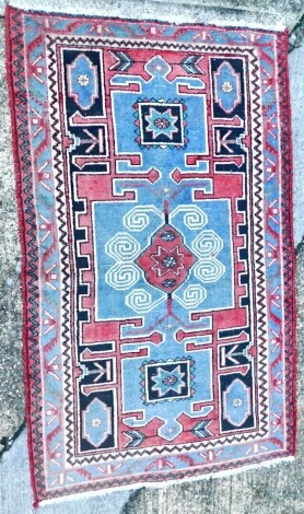 A vintage Hamadan village rug, with central medallion within compartments, in red, pale blue, etc., one wide, two narrow borders, 129cm x 204cm.