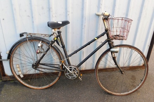 A mid century lady's bicycle, in black trim with basket.