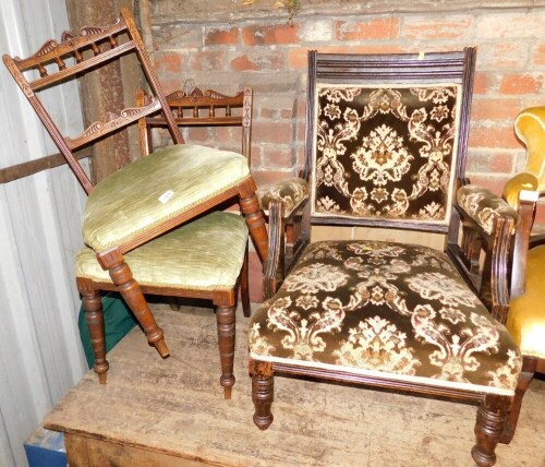 A pair of Edwardian oak bedroom chairs, each with a carved rail, overstuffed seat on turned tapering legs, together with an Edwardian open armchair, upholstered in brown foliate fabric.