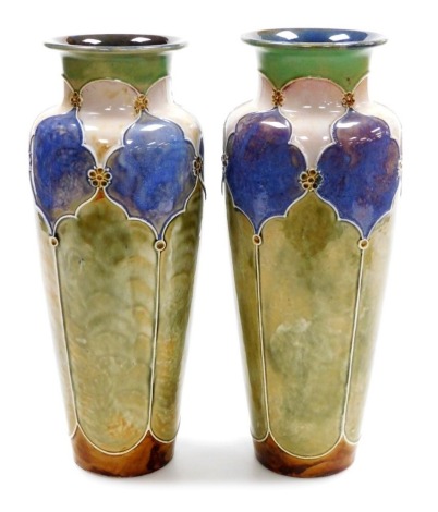 A pair of late 19thC Royal Doulton stoneware vases, of cylindrical tapering form with flared rims, decorated in Art Nouveau style in green, lilac and blue, pattern number 7822A, impressed marks, 33cm high.