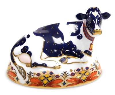 A Royal Crown Derby porcelain Friesian Cow 'Buttercup' porcelain paperweight, red printed marks and gold stopper, 12cm high.