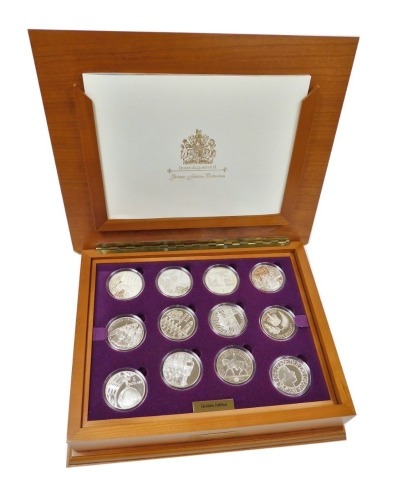 A Royal Mint Golden Jubilee collection, comprising of twenty four silver coins from the twelve Commonwealth countries, in a fitted wooden box with two trays, and explanatory booklet.