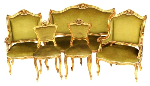 A late 19thC Continental parcel gilt salon suite, each carved with a cherub's head and floral crest rail, scrolling arms, overstuffed seat and back, raised on cabriole legs, comprising a two seater sofa, 132cm wide, pair of armchairs, and a pair of side c