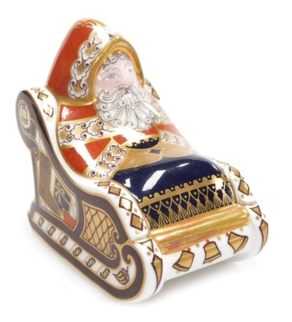 A Royal Crown Derby porcelain Santa in Sleigh paperweight, red printed marks and gold stopper, 10cm high.