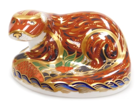 A Royal Crown Derby porcelain Otter paperweight, red printed marks and gold stopper, 7cm high.