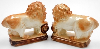 A pair of 19thC Scottish Bowness pottery lions, each modelled standing with a raised paw on a ball, on a stepped base, 29cm high. - 2