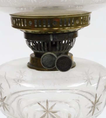 A late 19thC cut glass and brass oil lamp, with a clear and opaque floral etched shade, clear cut glass central reservoir, raised on an embossed brass column, on a painted socle base, 57cm high. - 2