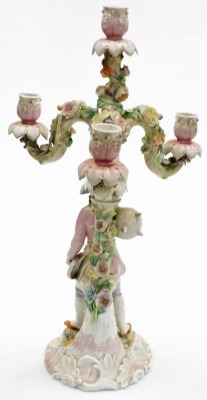 A late 19thC porcelain candelabrum, the candle arms modelled as tree branches with applied porcelain flowers, the central column modelled as a tree branch beside a gentleman holding a spoon and cooking pot, on a scroll base, gilt heightened, painted mark - 2