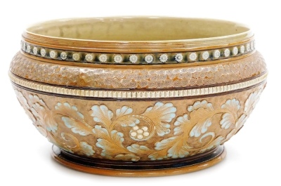 A late 19thC Royal Doulton stoneware bowl by Mark V Marshall, decorated with bands of raised flowers, incised roundels, flowers, leaves, etc., in greens, oranges and blues, model number 4133, impressed marks and monogram MVM, 14cm high, 28cm diameter.