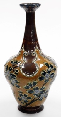 A late 19thC Royal Doulton Lambeth stoneware vase by Rosina Brown, of cylindrical tapering form with an elongated neck, decorated with blue and green flowering branches, with raised bead decorations against a two tone brown ground, model number 706, impre - 2